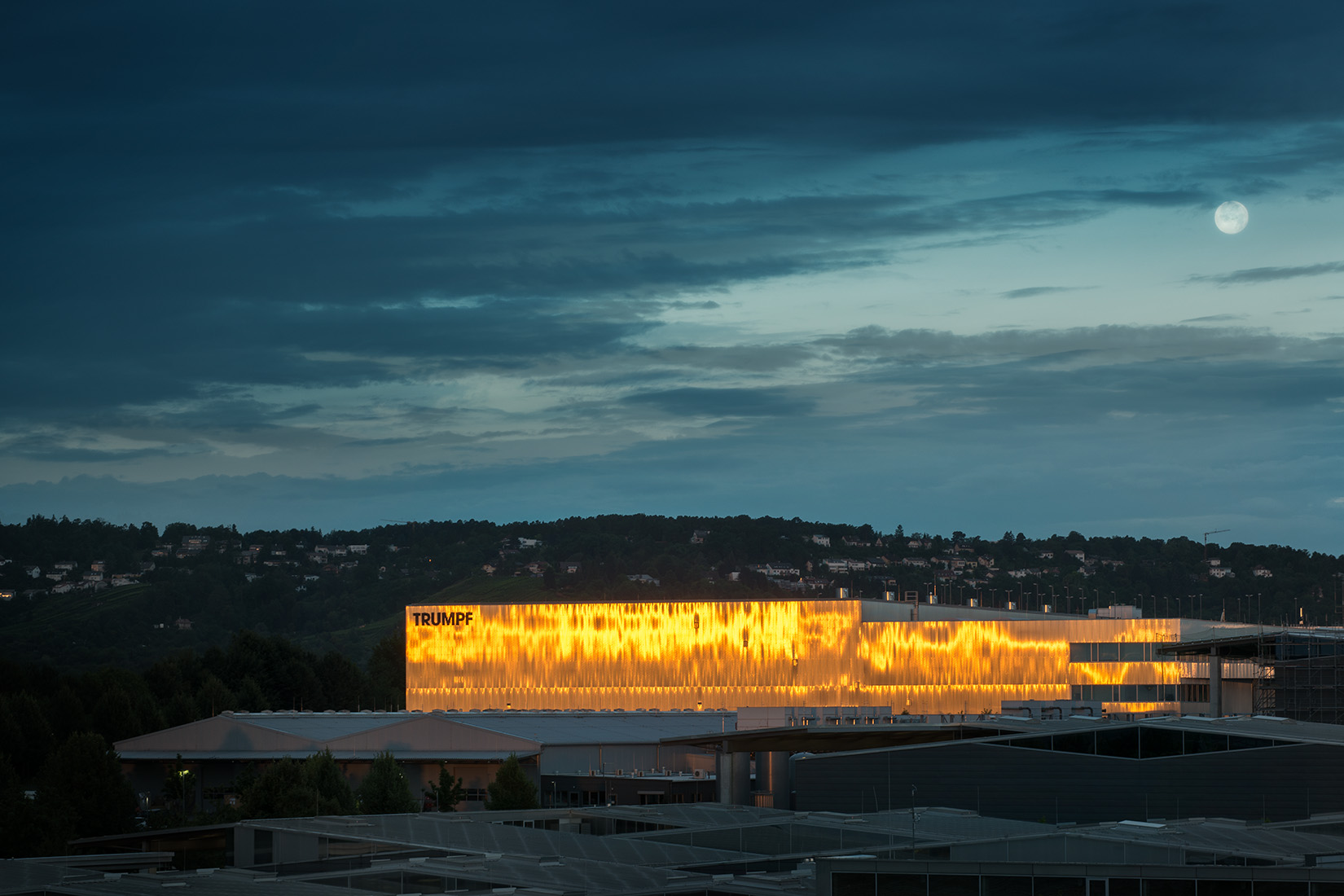 The Trumpf factory glowing brilliantly against the night sky