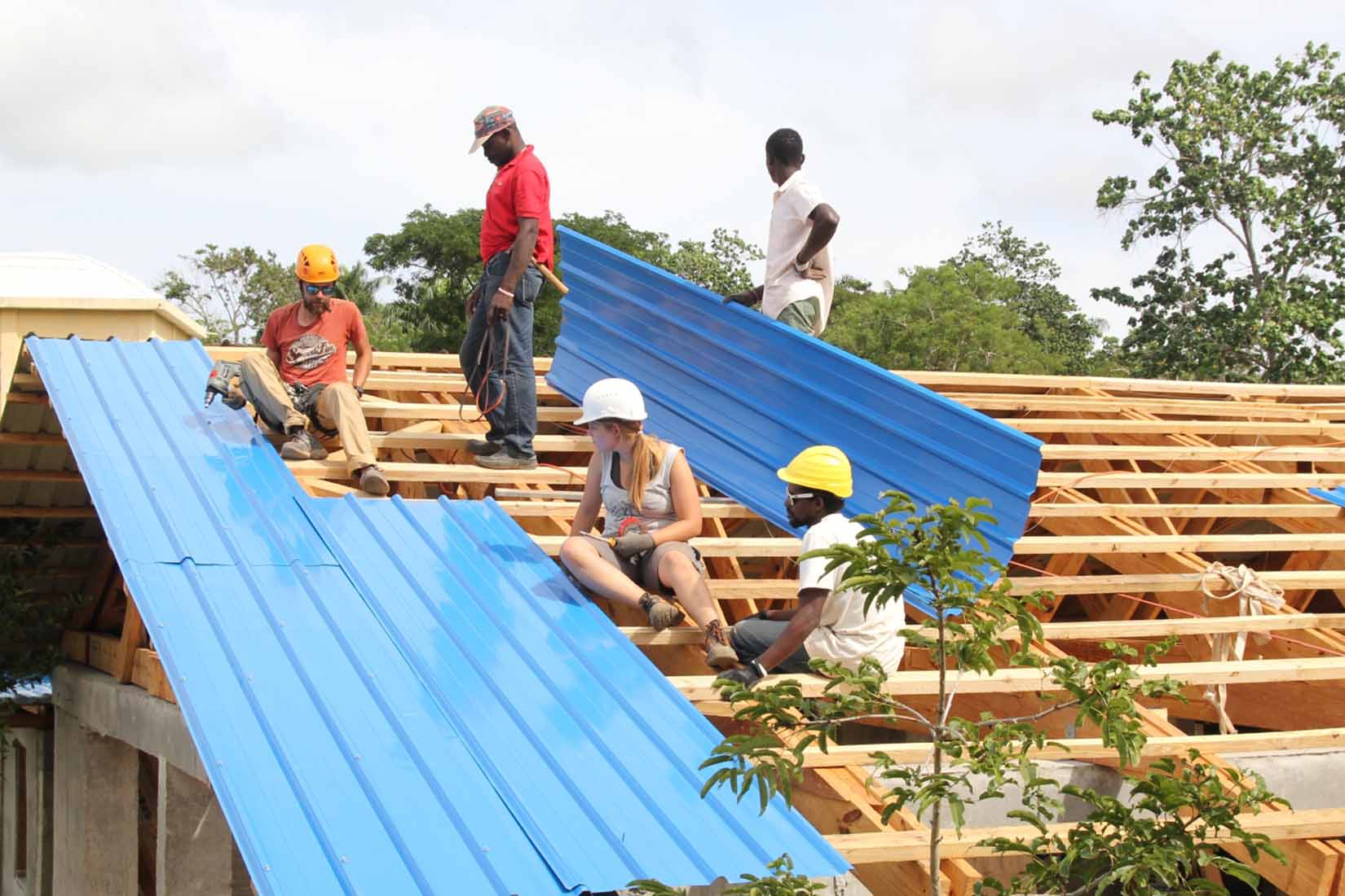 A team of construction workers installing a roof in Africa