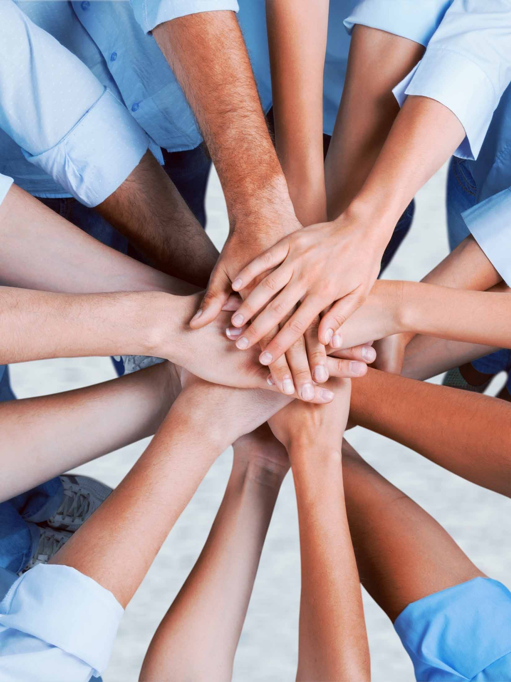 Many hands coming together in the center