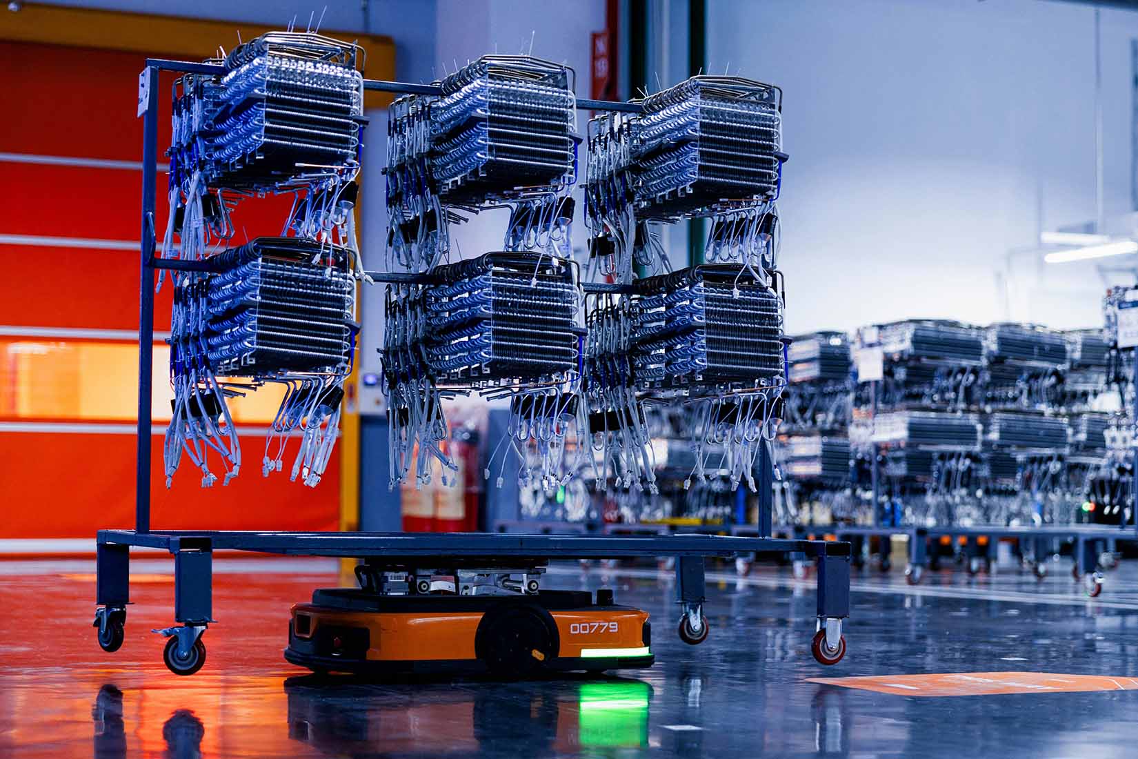 In a high-tech facility, a mobile robot carries multiple layers of equipment, highlighting automation in logistics.