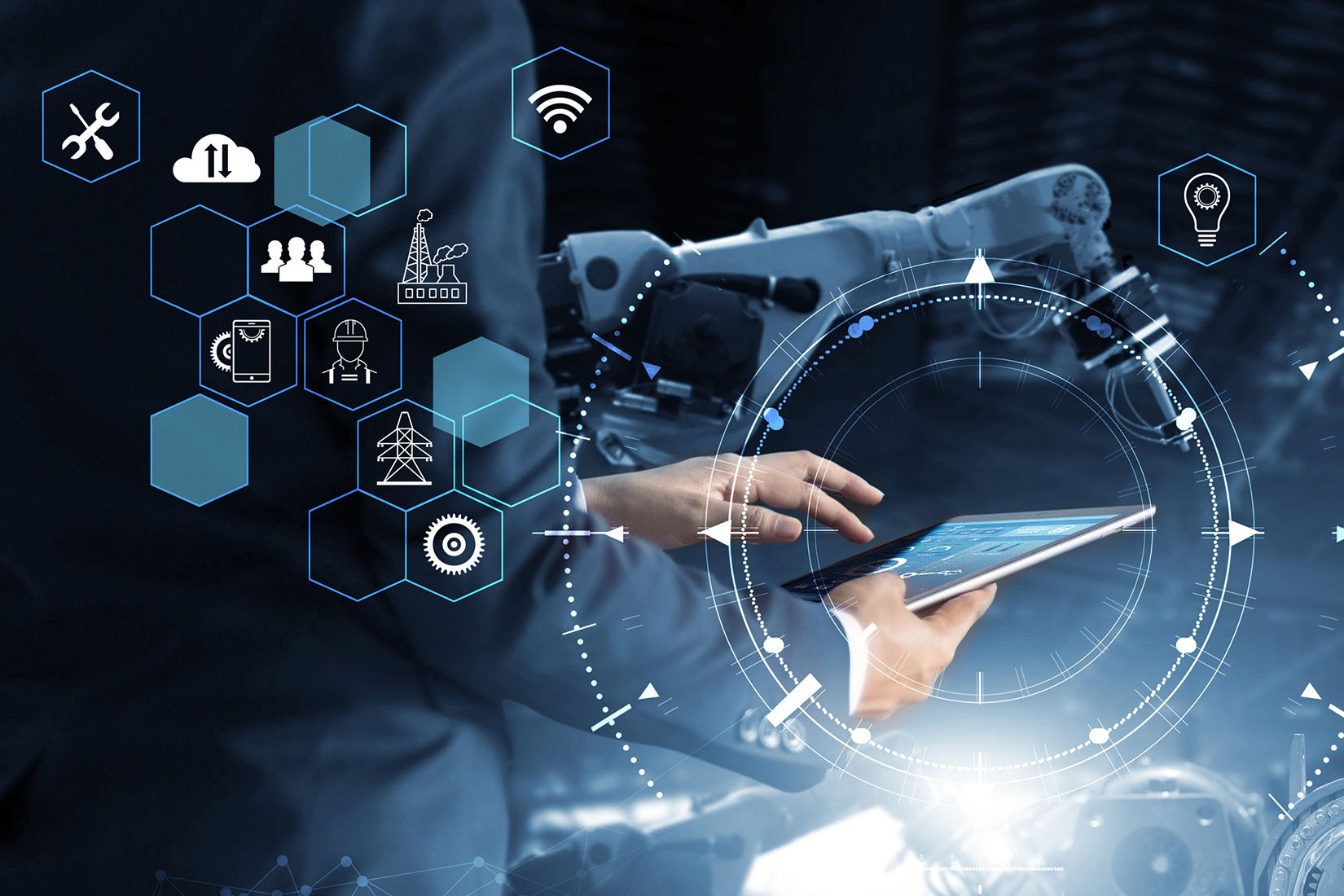 A close-up of a person's hands on a tablet, with a robotic arm and digital graphics illustrating connectivity and industry.