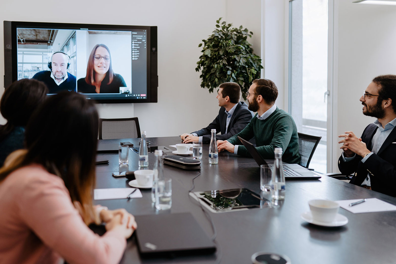 A meeting in the office with staff on video call
