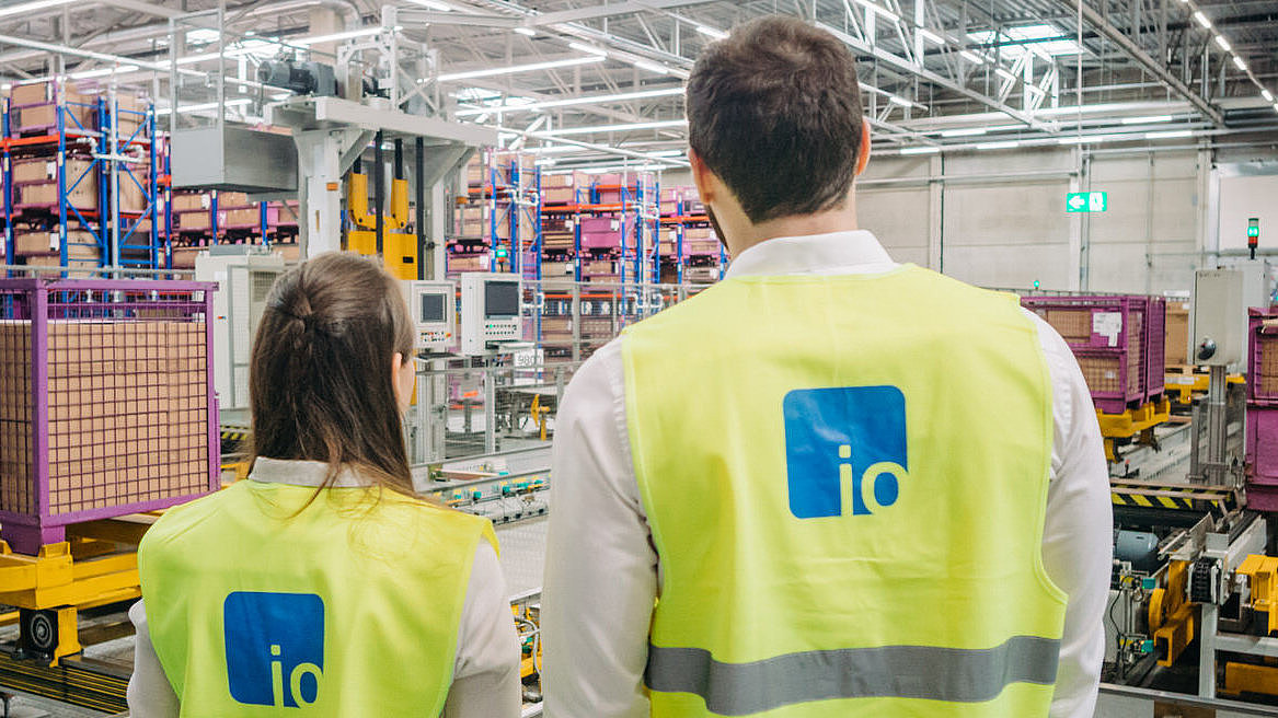 Back view of two employees with a view of high-bay warehouse