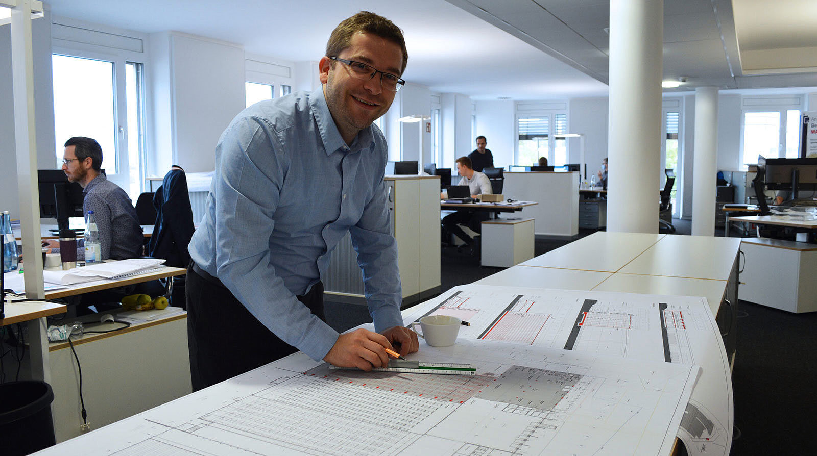 Markus Seidel bei Bauplanzeichnung im Büro