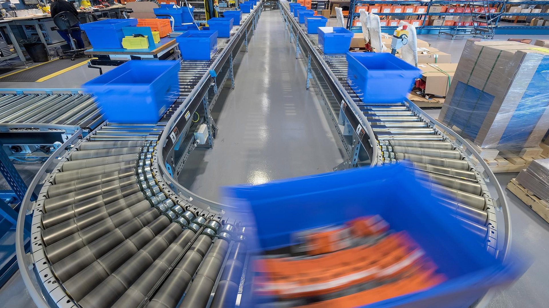 Förderanlage mit blauen Behältern in einer Logistikhalle