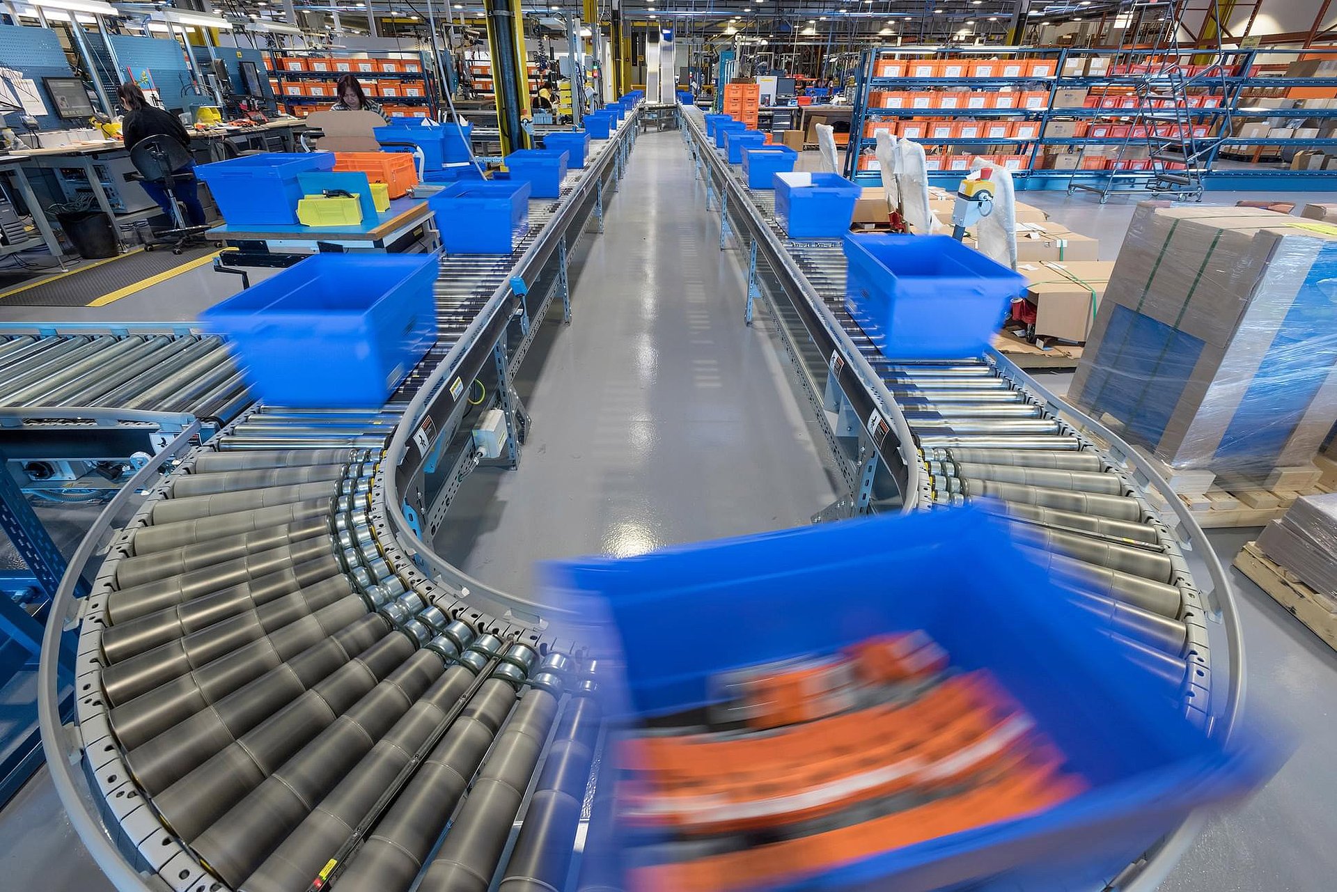 Conveyor system with blue containers in a logistics hall