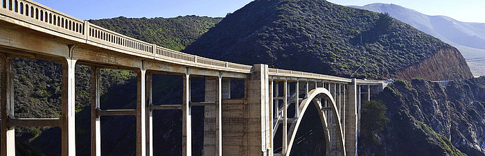Brücke mit grünen Bergen im Hintergrund