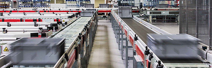 Laufbänder mit Kisten in einer Logistikhalle