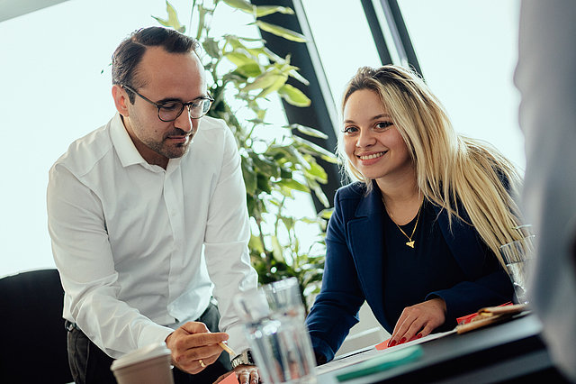 Zwei Personen sitzen gemeinsam und Besprechen Aufgaben