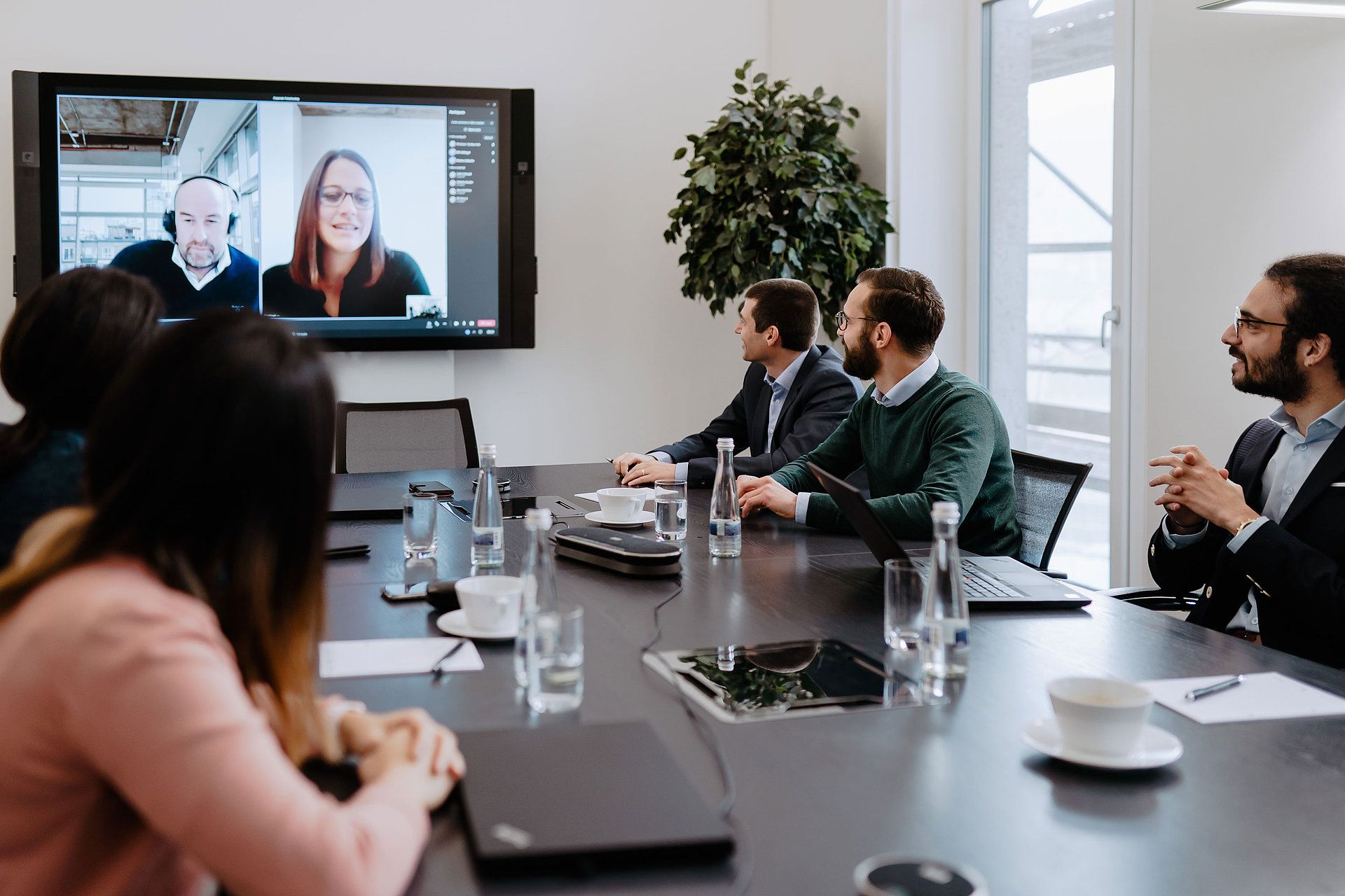 A meeting in the office with staff on video call