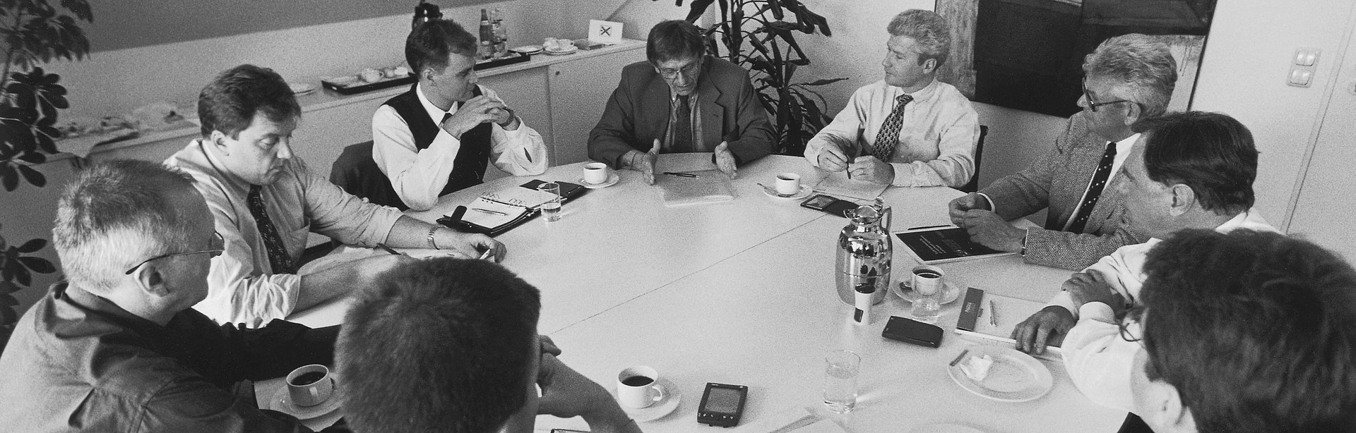 Black and white picture of a team meeting in the office