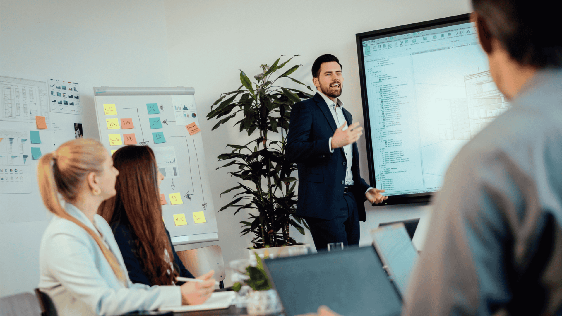 Professionelle Besprechung zwischen vier Kollegen mit Visualisierungen und Notizen