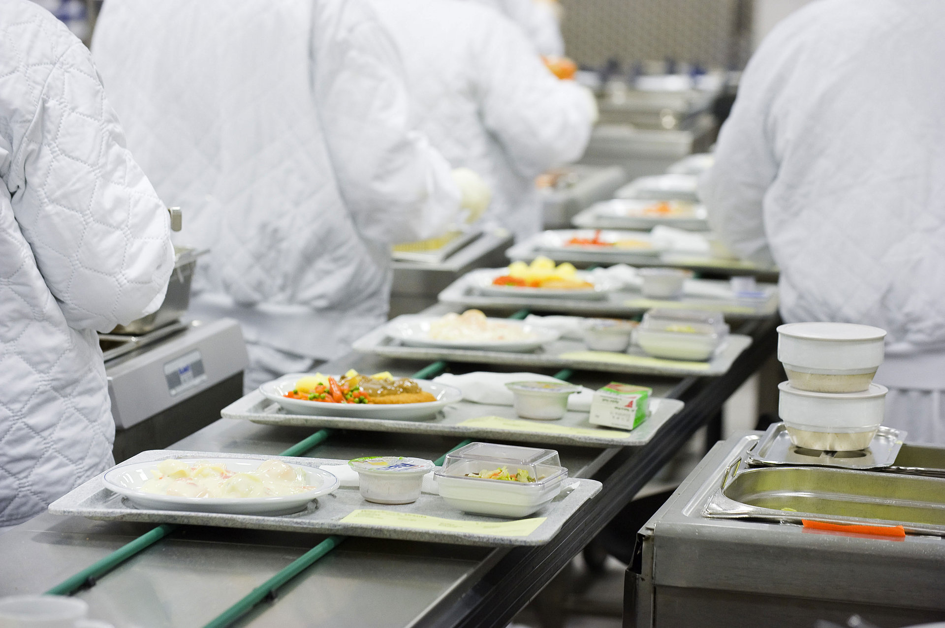 Meals for aircraft on trays are transported on a conveyor belt