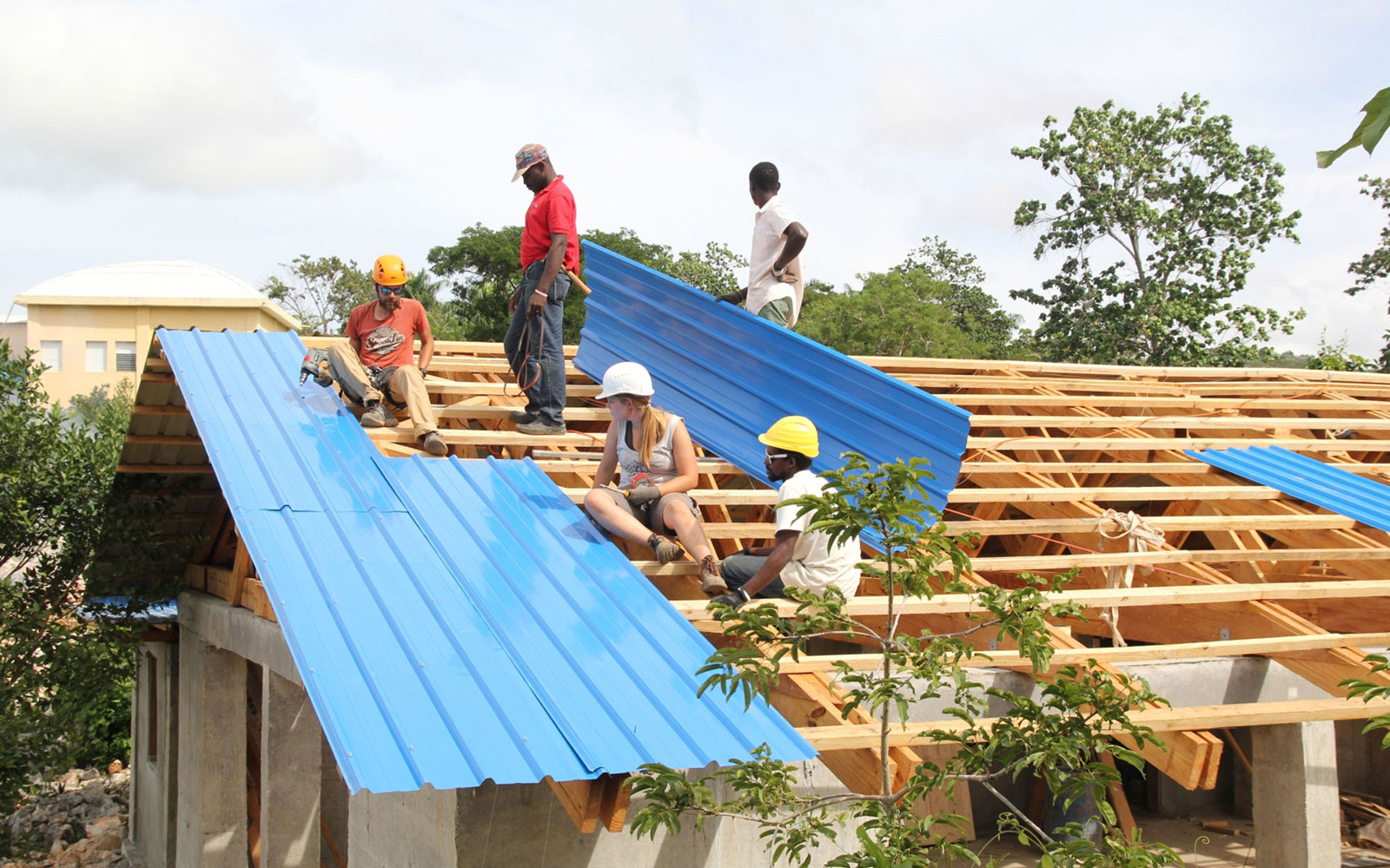 Fünf Menschen decken gemeinsam ein Dach.